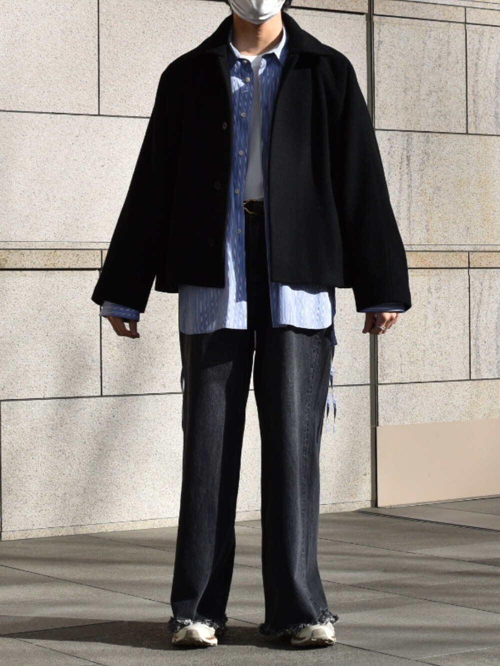 ブルー系のショルダーバッグ、ブルー系のビジネスシャツ、ブラック系のデニムパンツを着用したメンズの冬コーディネートの3枚目の写真