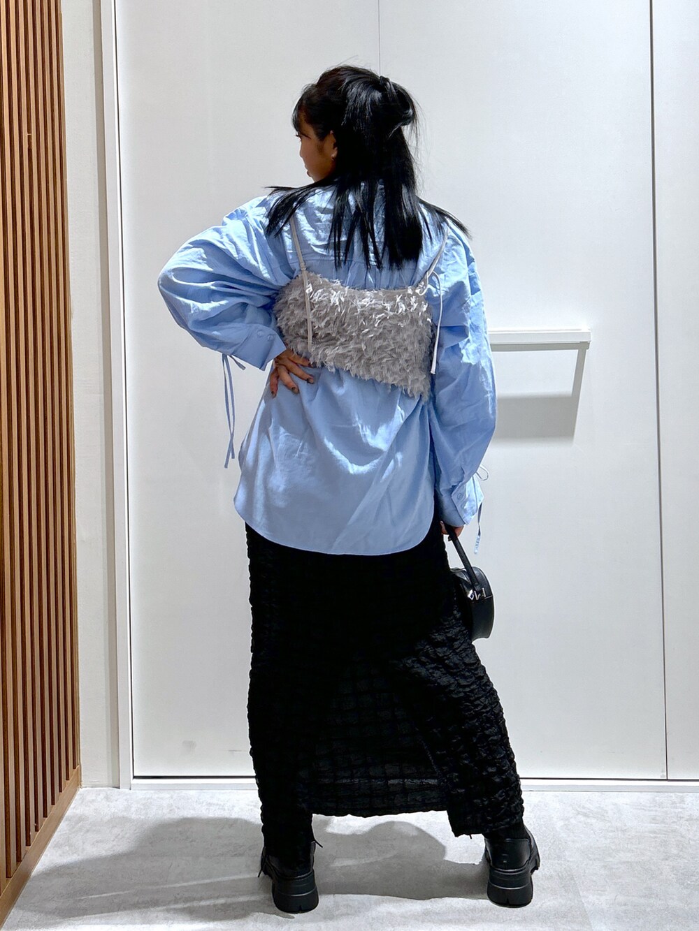 グレー系のキャミソール、ブルー系のシャツ/ブラウス、ブラック系のスカートを着用したレディースの秋コーディネートの3枚目の写真