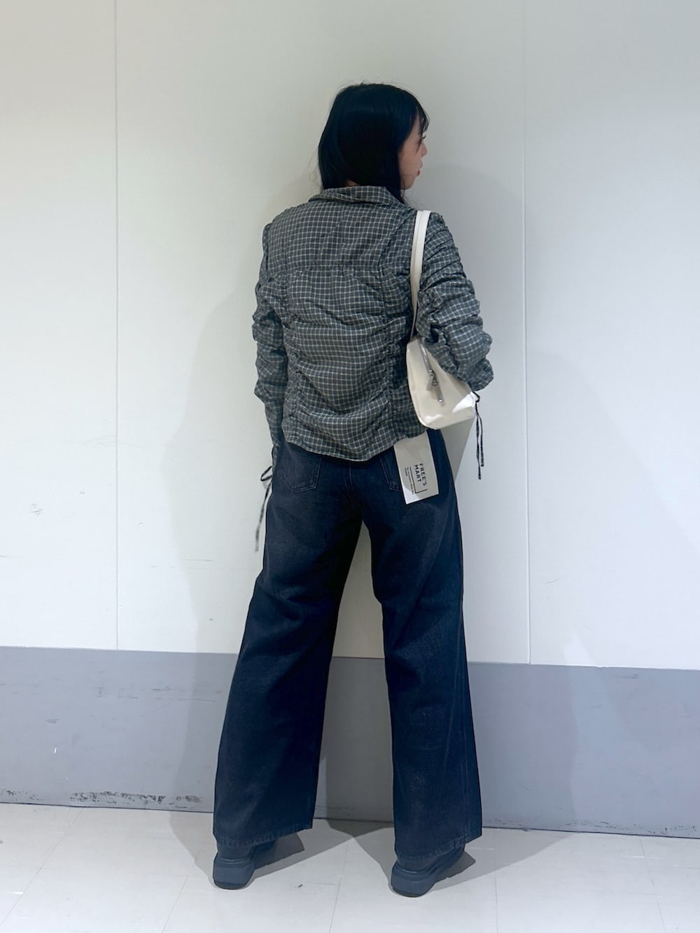 ブラック系のシャツ/ブラウス、ブラック系のデニムパンツ、ホワイト系のショルダーバッグを着用したレディースの秋コーディネートの3枚目の写真