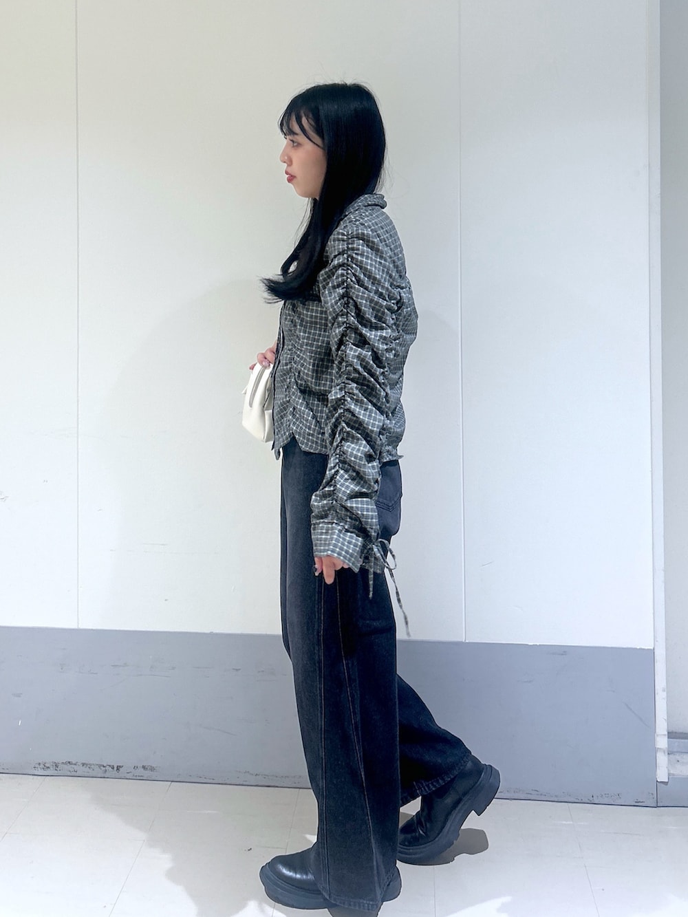 ブラック系のシャツ/ブラウス、ブラック系のデニムパンツ、ホワイト系のショルダーバッグを着用したレディースの秋コーディネートの2枚目の写真
