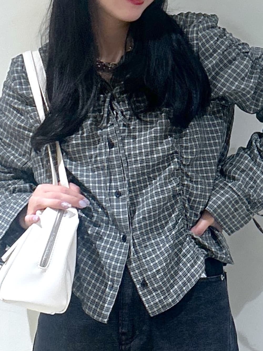 ブラック系のシャツ/ブラウス、ブラック系のデニムパンツ、ホワイト系のショルダーバッグを着用したレディースの秋コーディネートの4枚目の写真