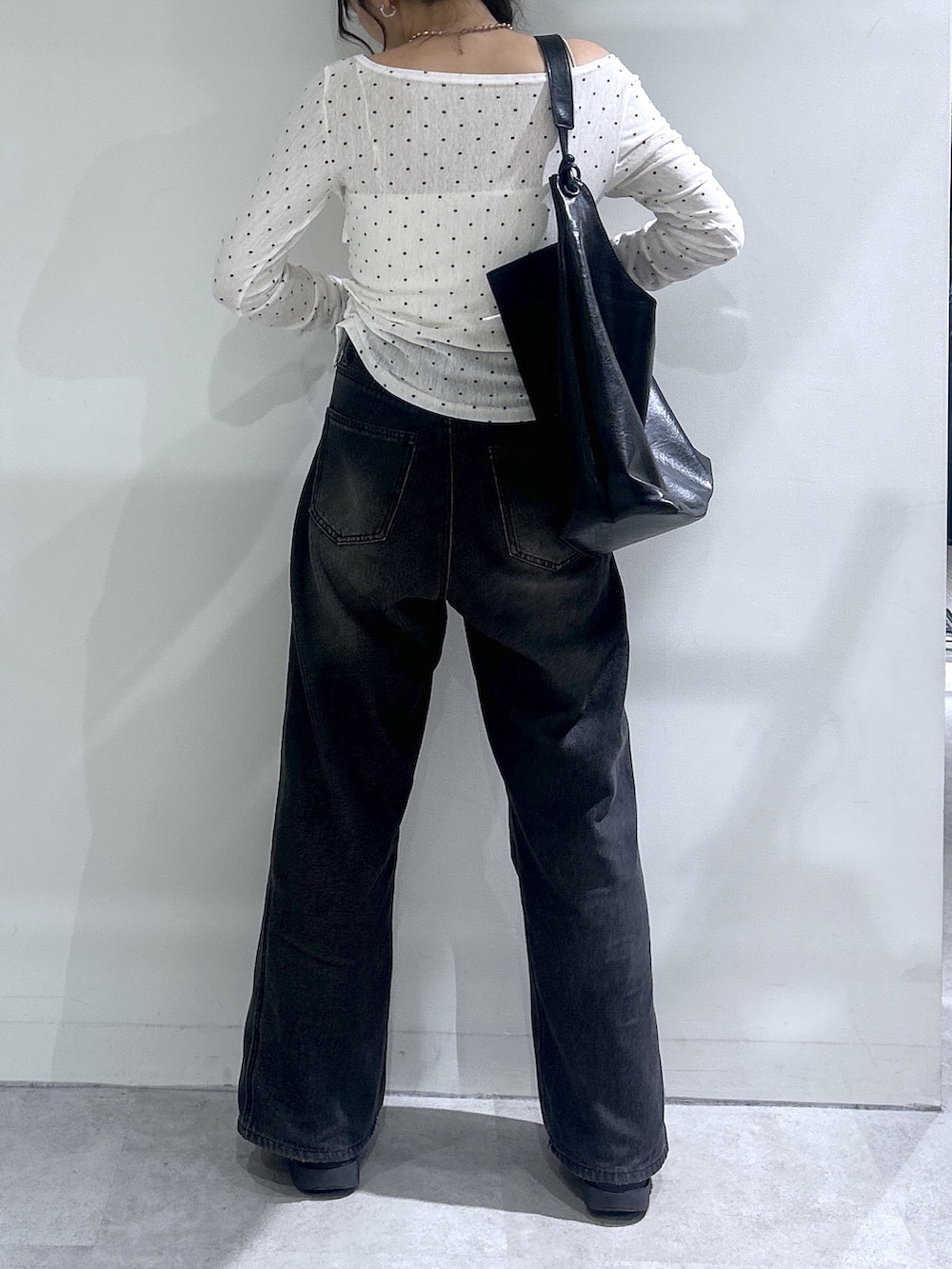 ブラック系のデニムパンツ、ホワイト系のTシャツ/カットソー、ホワイト系のキャミソールを着用したレディースの秋コーディネートの3枚目の写真