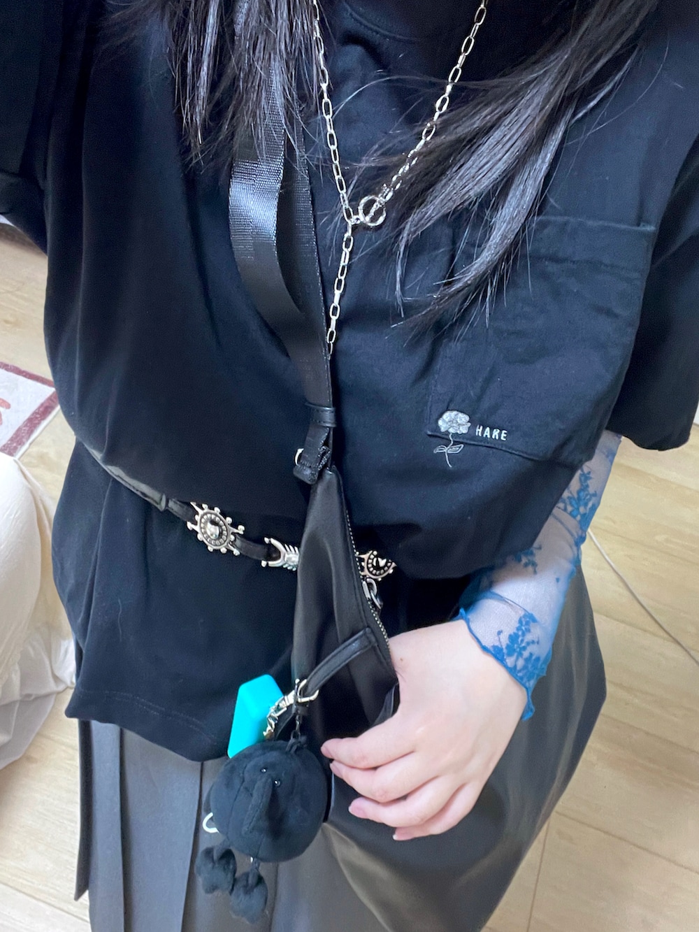 グレー系のスカート、ブラック系のショルダーバッグ、ブラック系のTシャツ/カットソーを着用したレディースの夏コーディネートの2枚目の写真