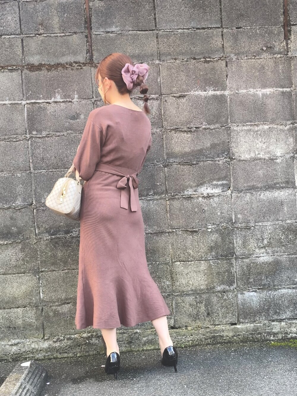 ブラウン系のワンピース、ブラック系のパンプス、ベージュ系のトートバッグを着用したレディースの春コーディネートの2枚目の写真