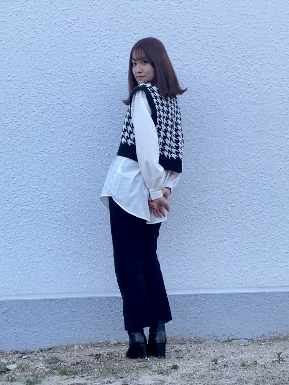 ブラック系のニット/セーター、ブラック系のその他パンツ、ブラック系のブーツを着用したレディースの春コーディネートの2枚目の写真