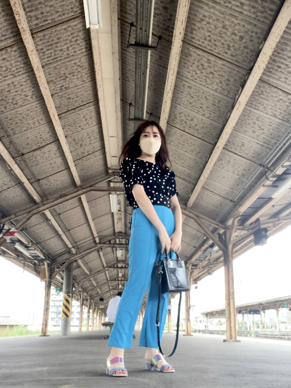 ブラック系のシャツ/ブラウス、ブルー系のスラックス、ブルー系のサンダルを着用したレディースの夏コーディネートの2枚目の写真