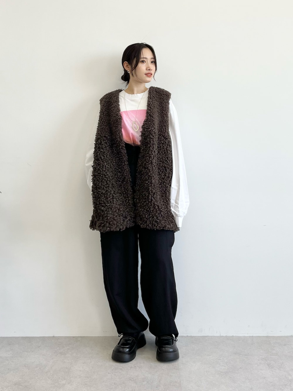 ホワイト系のTシャツ/カットソー、ブラウン系のベスト、ブラック系のカーゴパンツを着用したレディースの夏コーディネートの2枚目の写真