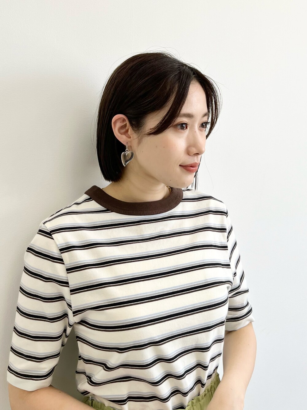 グリーン系のその他パンツ、ブラウン系のショルダーバッグ、ホワイト系のTシャツ/カットソーを着用したレディースの春コーディネートの3枚目の写真