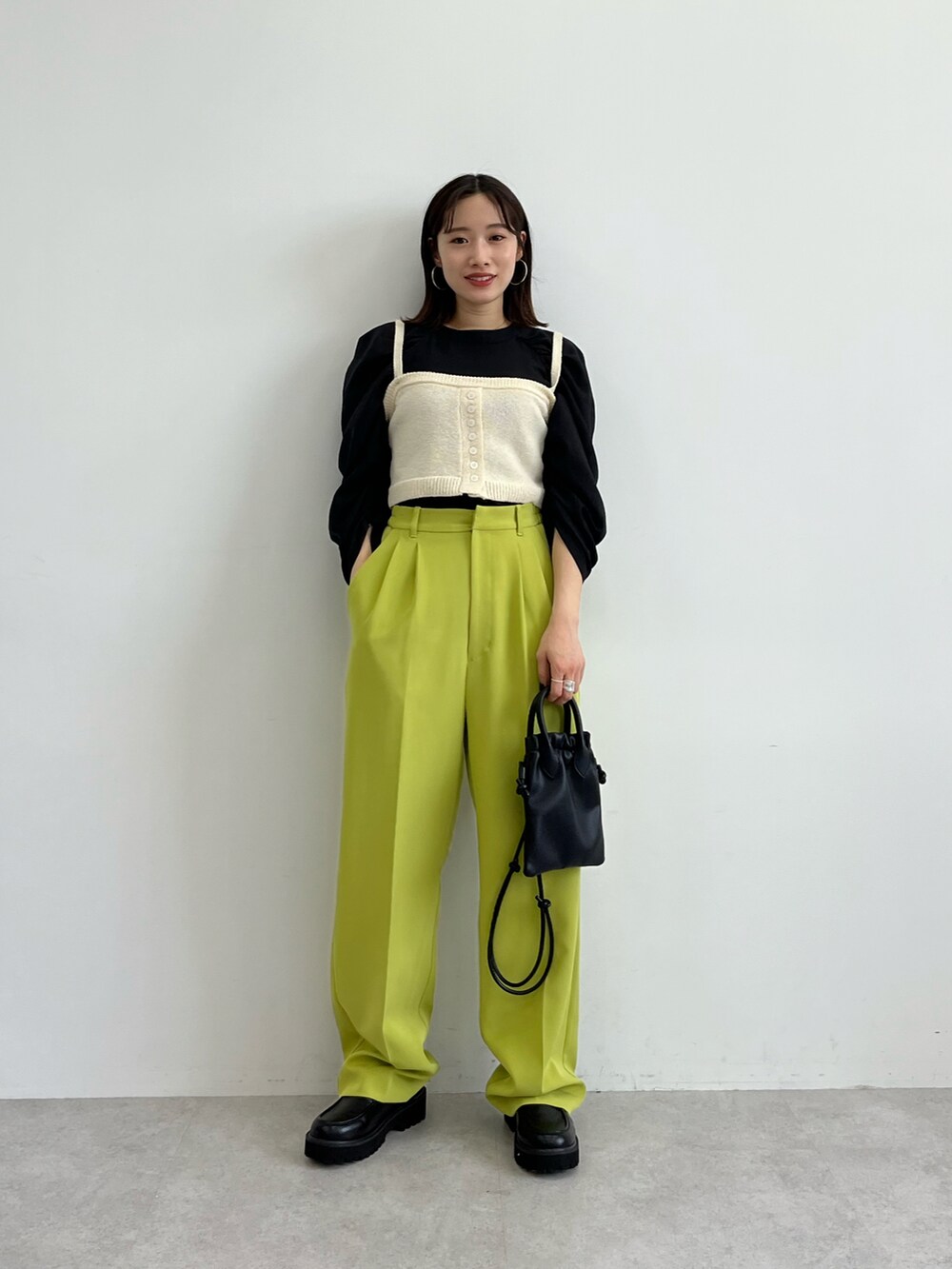 ブラック系のシャツ/ブラウス、ホワイト系のベスト、ブラック系のショルダーバッグを着用したレディースの冬コーディネートの3枚目の写真