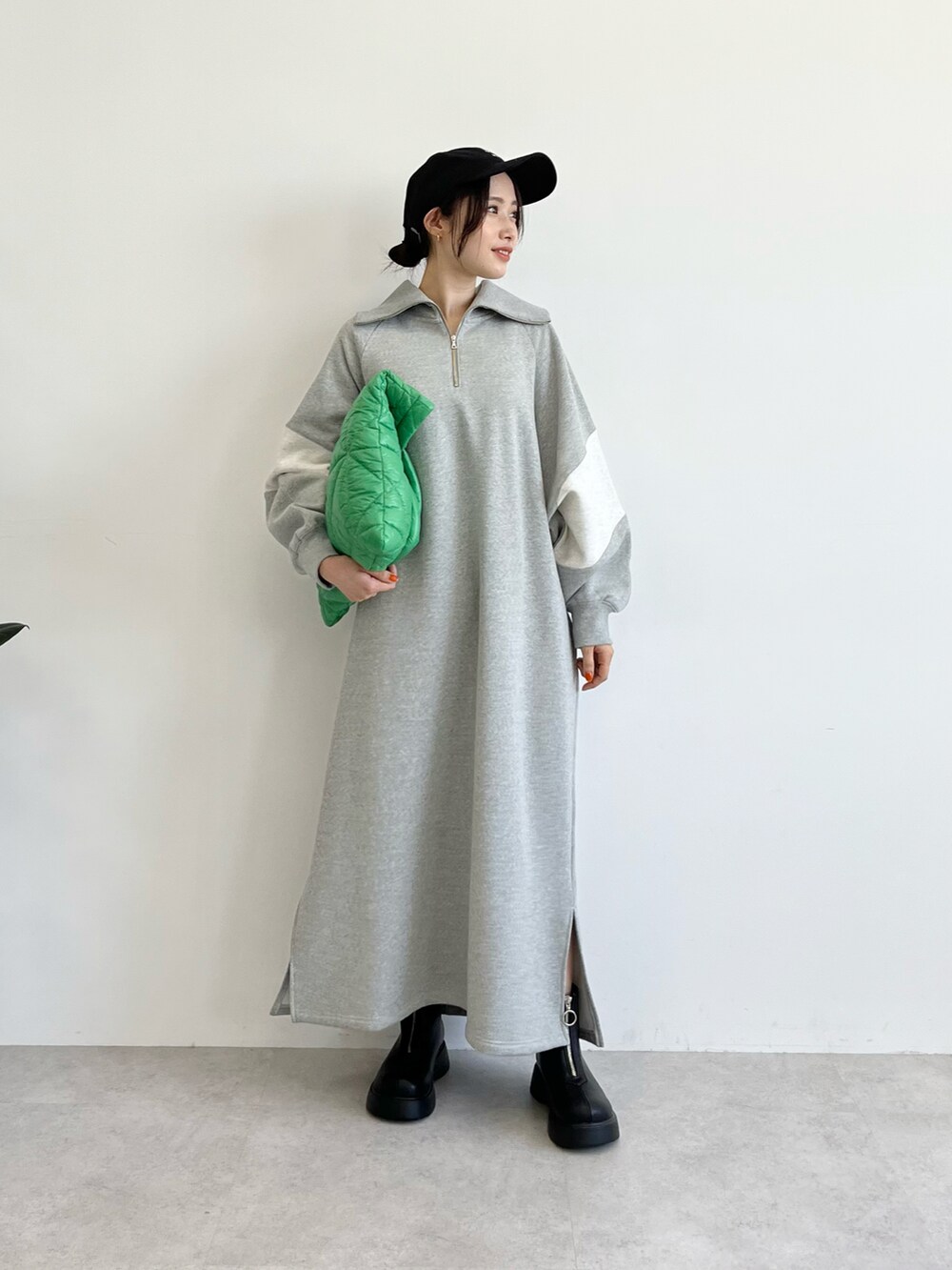 グリーン系のトートバッグ、グレー系のワンピース、ブラック系のブーツを着用したレディースの夏コーディネートの2枚目の写真