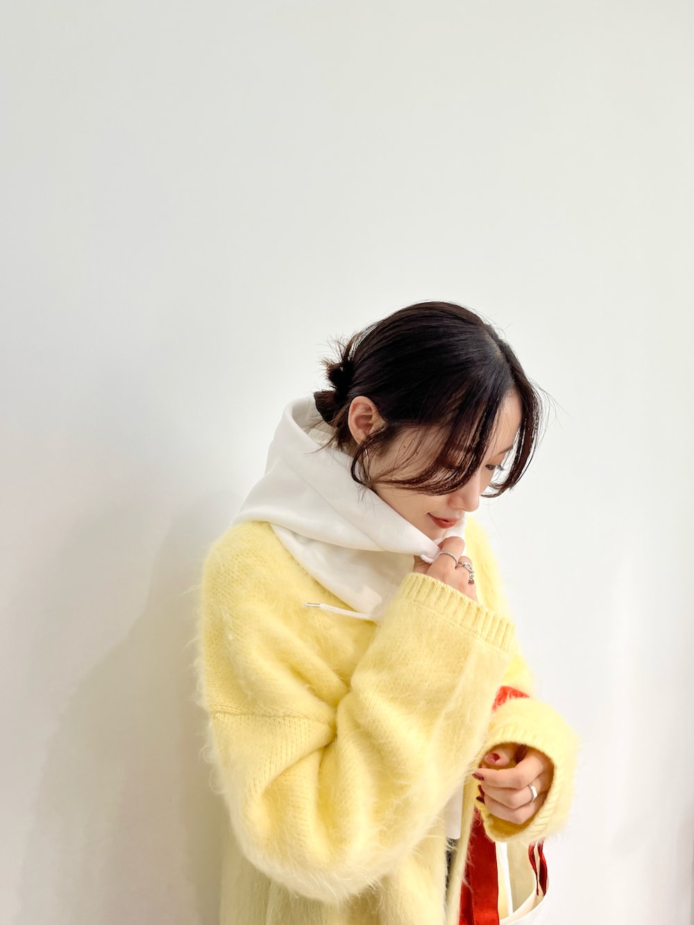 ホワイト系のTシャツ/カットソー、ベージュ系のカーディガン/ボレロ、グレー系のスカートを着用したレディースの秋コーディネートの2枚目の写真