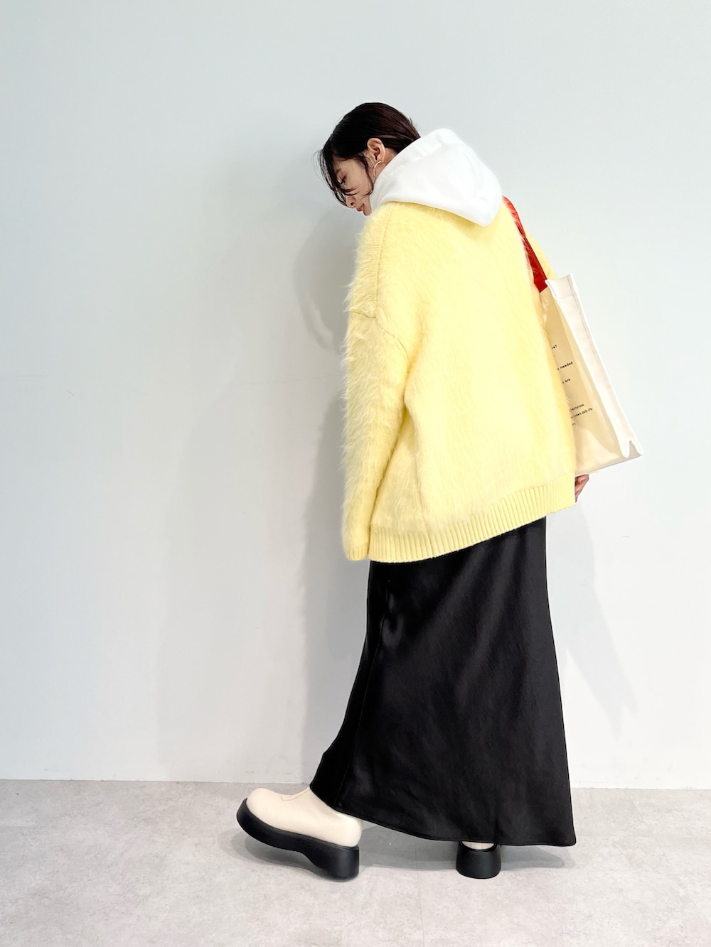 ホワイト系のTシャツ/カットソー、ベージュ系のカーディガン/ボレロ、グレー系のスカートを着用したレディースの秋コーディネートの3枚目の写真