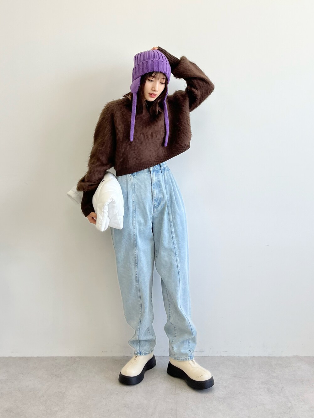 ブラウン系のニット/セーター、ホワイト系のトートバッグ、ブルー系のデニムパンツを着用したレディースの秋コーディネートの3枚目の写真