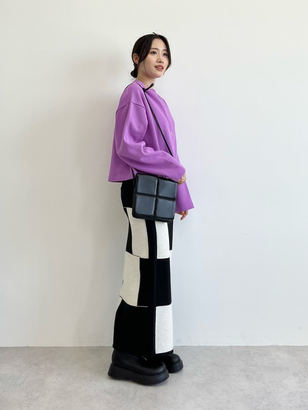 パープル系のカーディガン/ボレロ、ブラック系のショルダーバッグ、ブラック系のスカートを着用したレディースの夏コーディネートの2枚目の写真