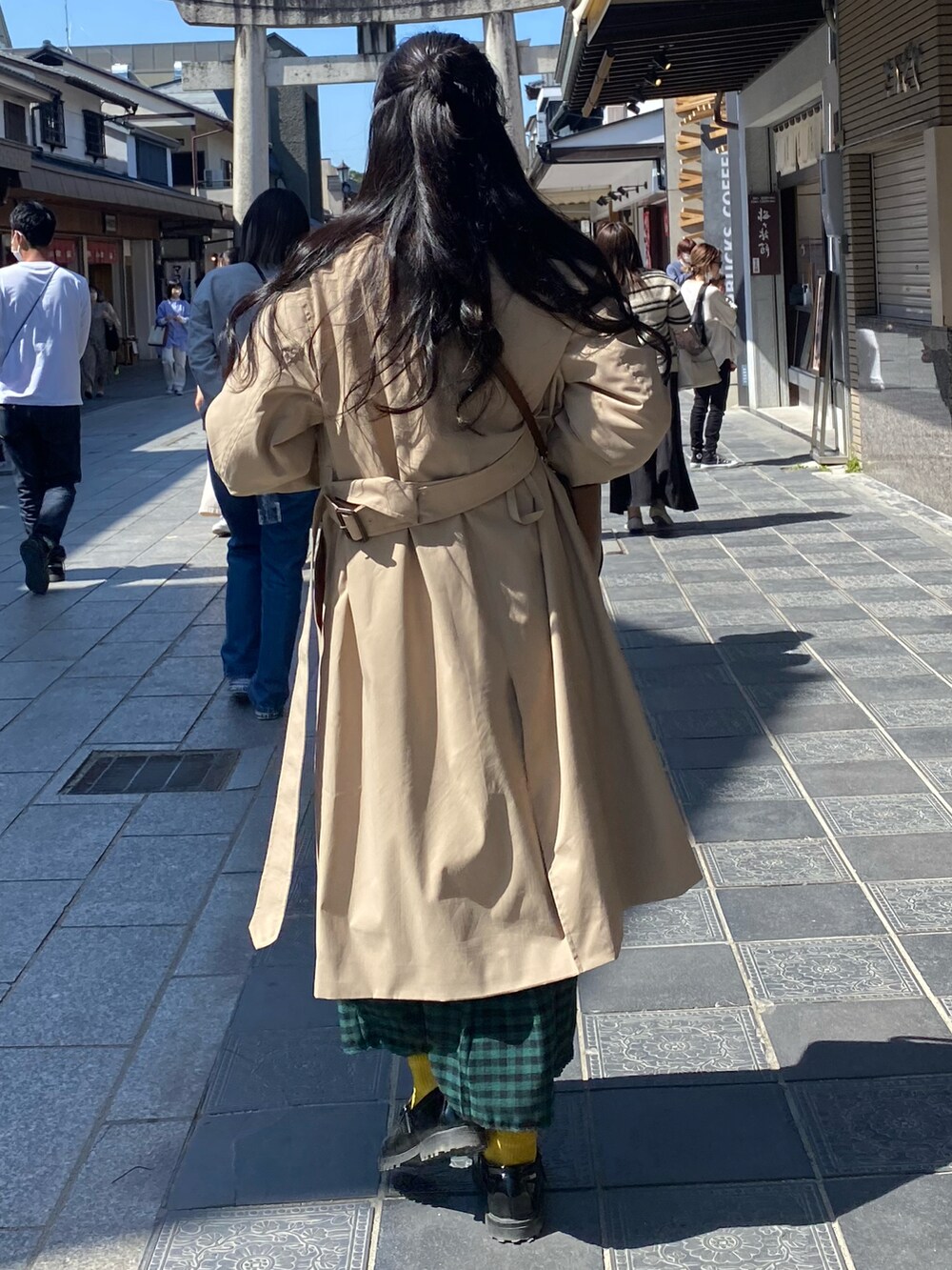 ブルー系のデニムパンツ、ホワイト系のTシャツ/カットソー、ブラウン系のジャケット/アウターを着用したレディースの春コーディネートの2枚目の写真