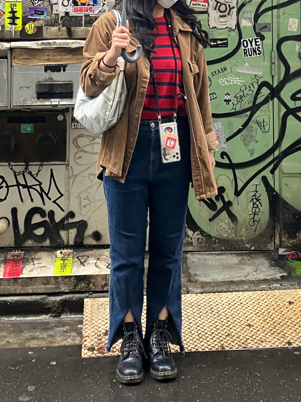 ブラウン系のシャツ/ブラウス、ブルー系のデニムパンツ、ブラック系のブーツを着用したレディースの春コーディネートの2枚目の写真