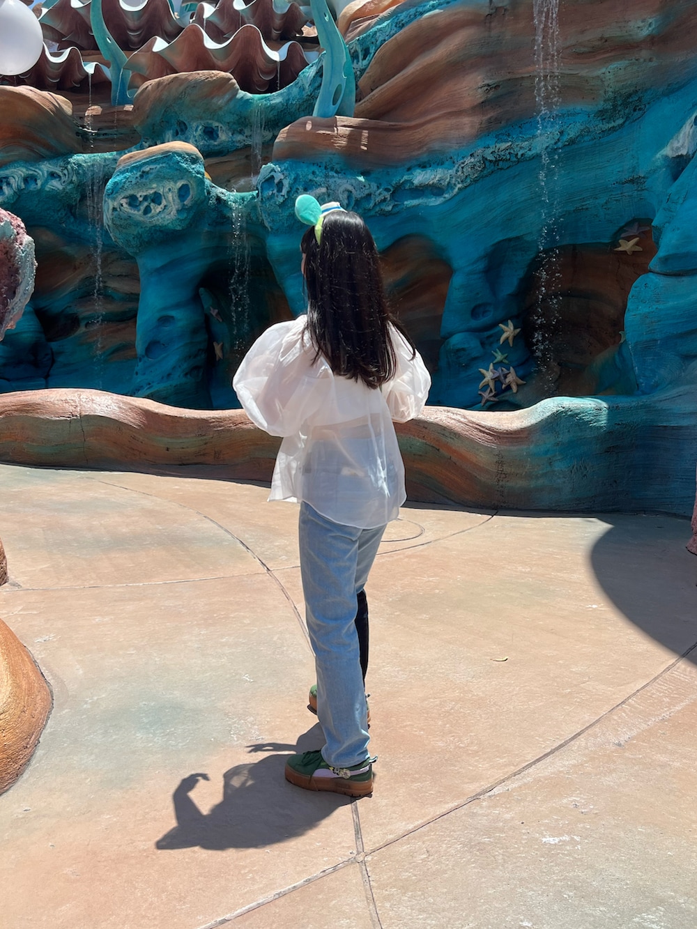 ホワイト系のシャツ/ブラウス、ブルー系のデニムパンツ、グリーン系のスニーカーを着用したレディースの夏コーディネートの2枚目の写真