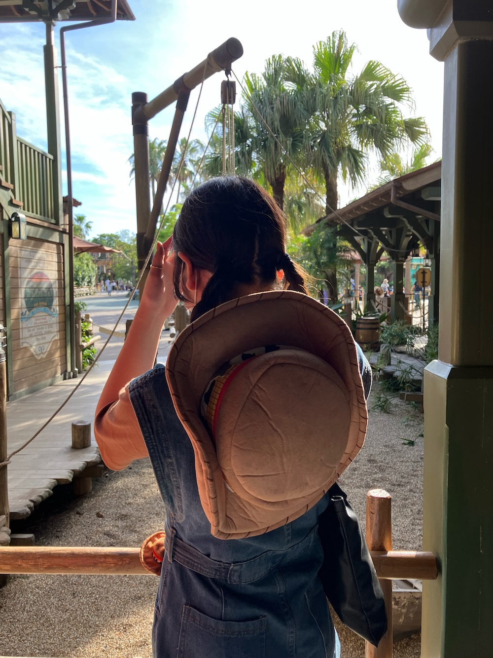 ブルー系のつなぎ/オールインワン、ブラック系のトートバッグ、ブラウン系のTシャツ/カットソーを着用したレディースの夏コーディネートの2枚目の写真