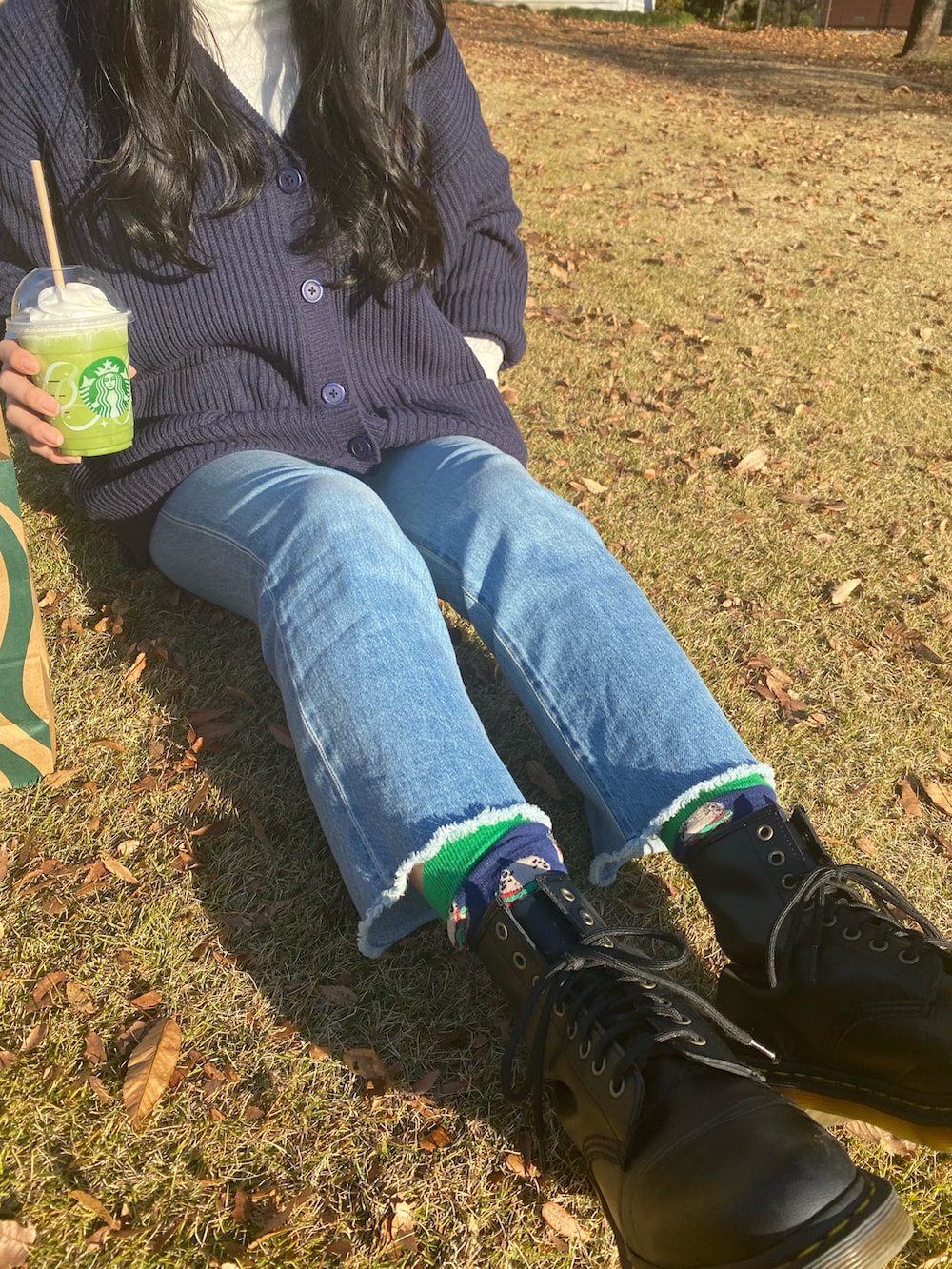 ブルー系のステンカラーコート、ブラック系のブーツ、ブラック系のバックパック/リュックを着用したレディースの冬コーディネートの2枚目の写真