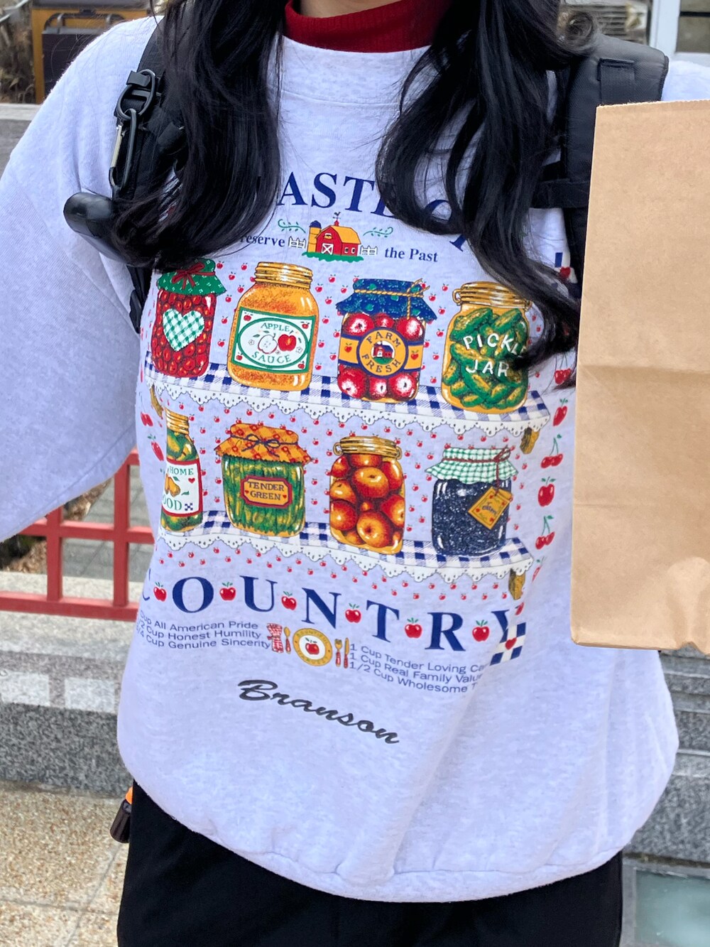 ホワイト系のスウェット、ブラック系のスラックス、ブラック系のブーツを着用したレディースの冬コーディネートの2枚目の写真