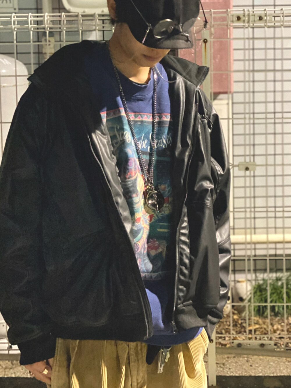 ブラック系のブルゾン、シルバー系のネックレス、シルバー系のメガネを着用したメンズの春コーディネートの2枚目の写真