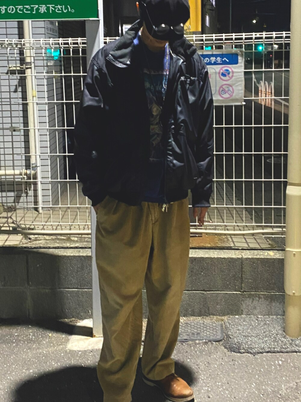 ブラック系のブルゾン、シルバー系のネックレス、シルバー系のメガネを着用したメンズの春コーディネートの3枚目の写真