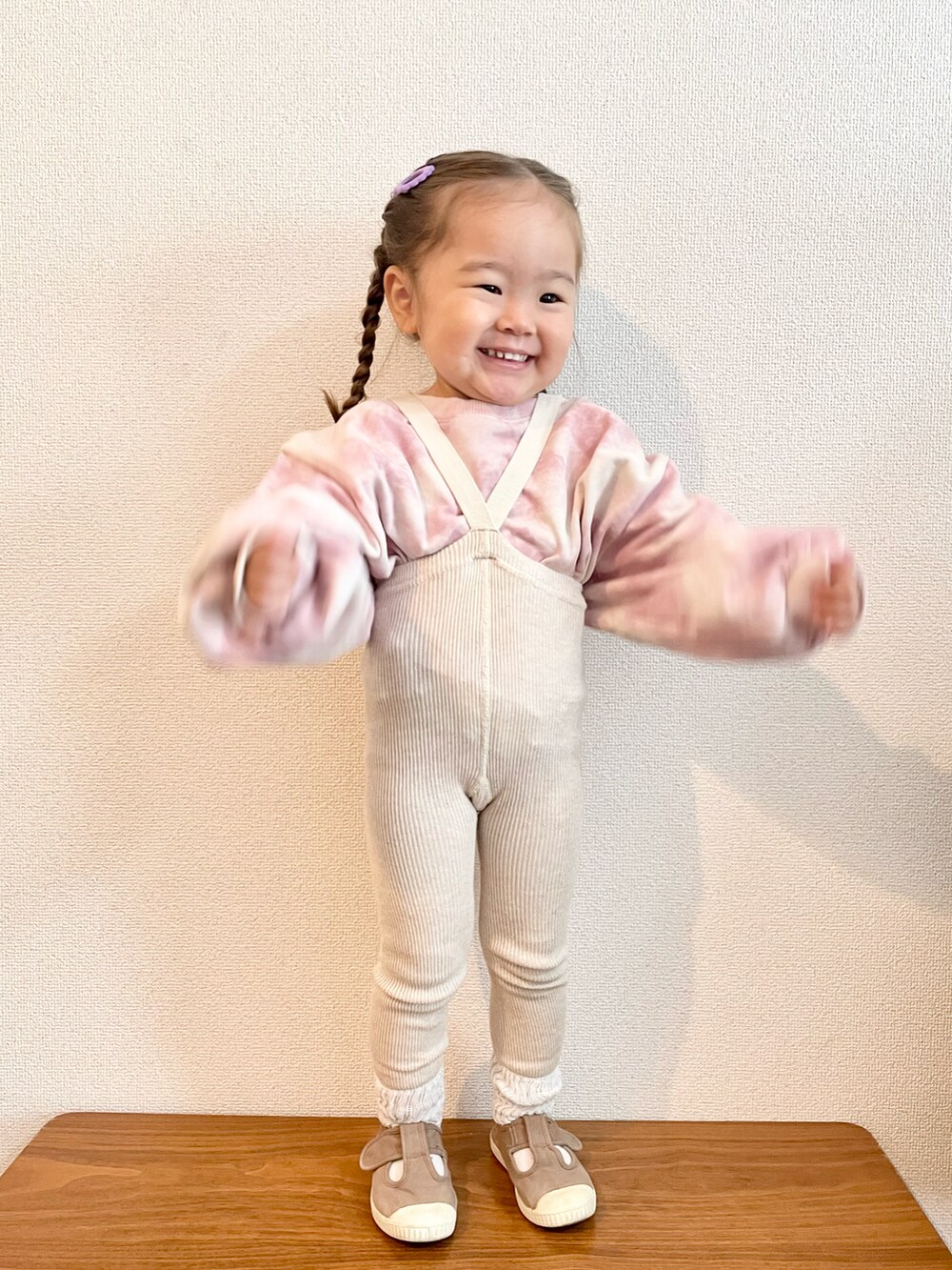 ピンク系のスウェット、ブラウン系のスニーカー、パープル系のバレッタ/ヘアクリップを着用したキッズの秋コーディネートの3枚目の写真