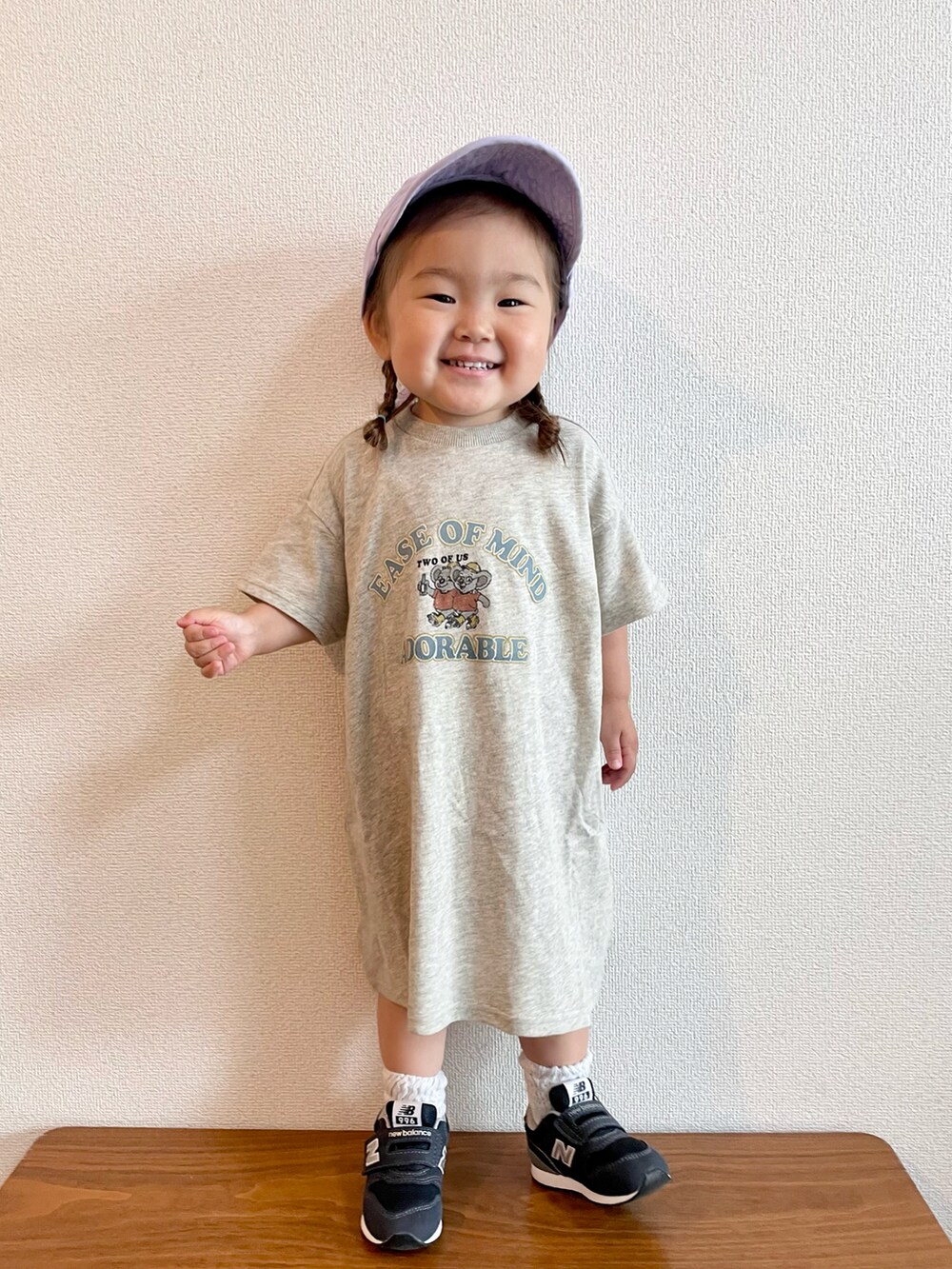 ホワイト系のワンピース、ブルー系のスニーカー、パープル系のキャップを着用したキッズの春コーディネートの3枚目の写真