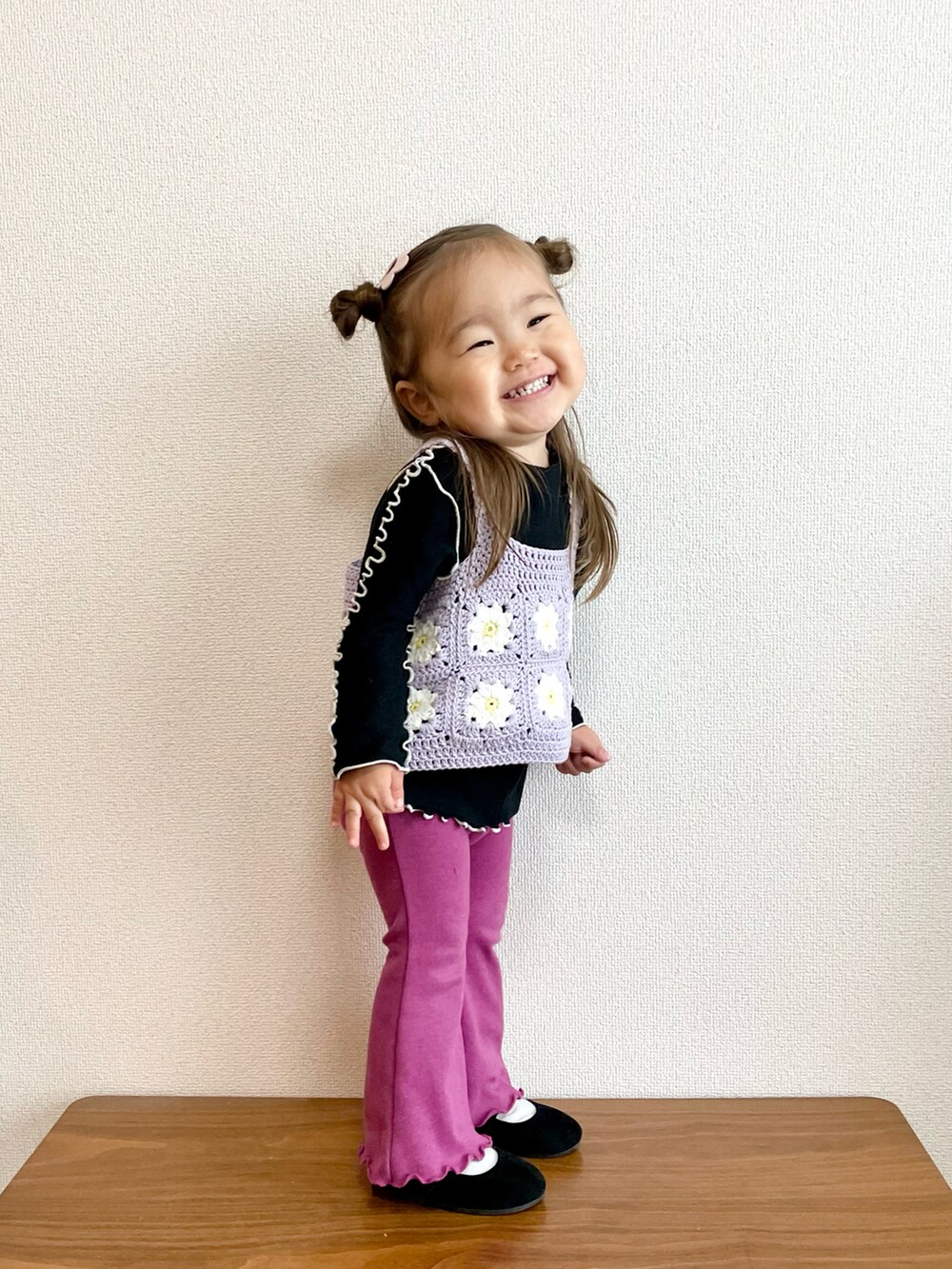 ブラック系のTシャツ/カットソー、パープル系のニット/セーター、パープル系のその他パンツを着用したキッズの冬コーディネートの2枚目の写真