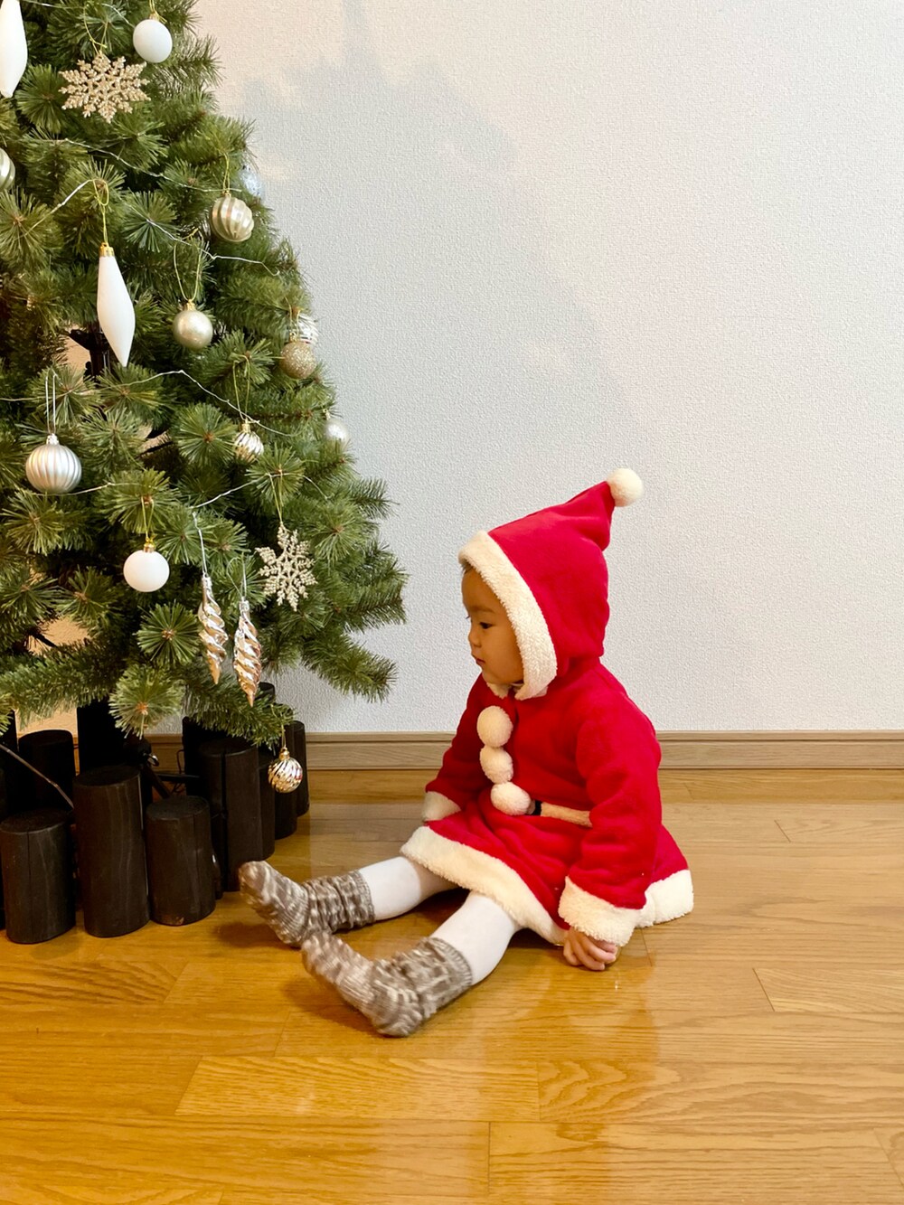 ベージュ系のTシャツ/カットソー、レッド系のワンピース、ベージュ系のブーツを着用したキッズの冬コーディネートの2枚目の写真