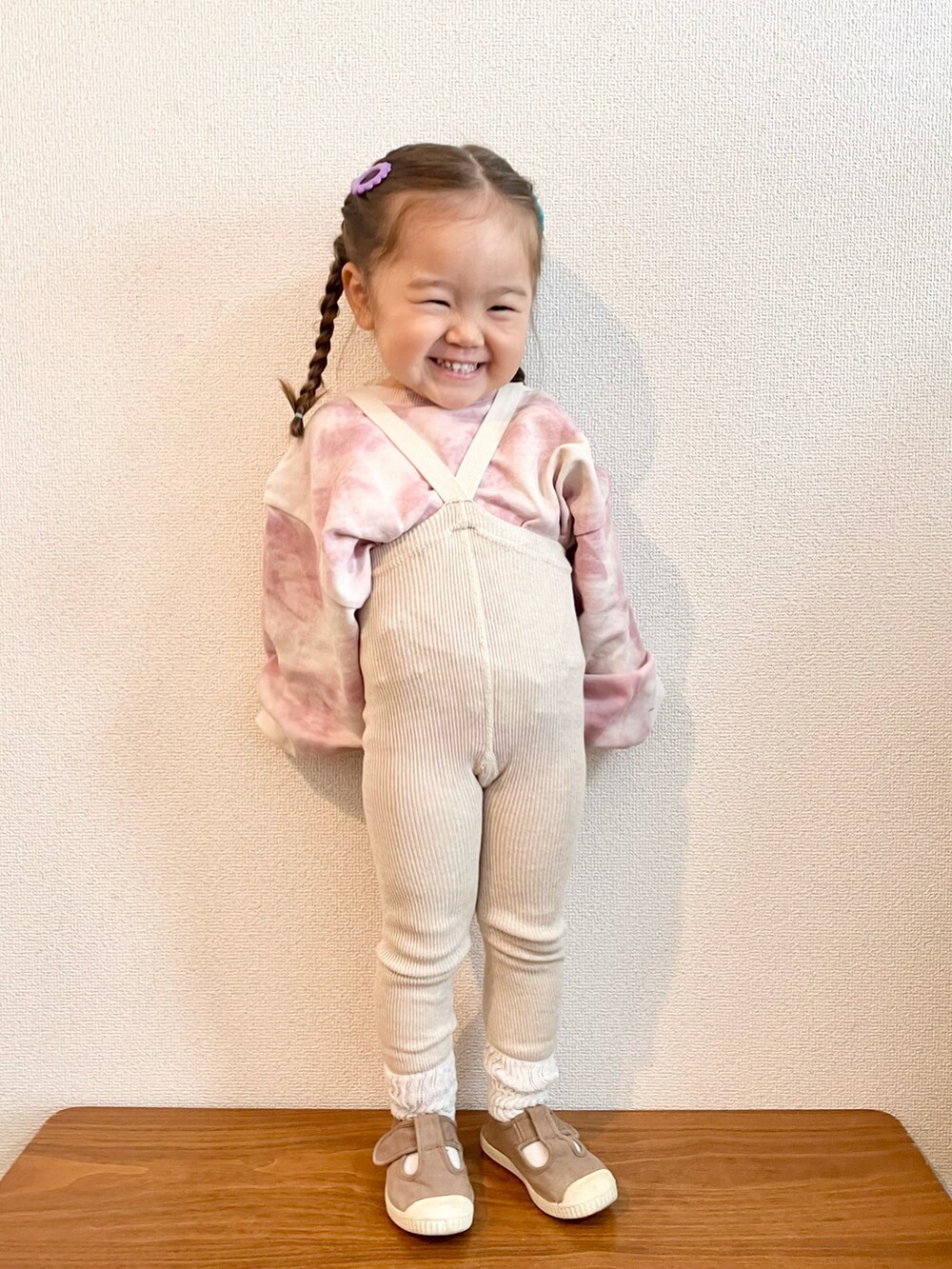 ピンク系のスウェット、ブラウン系のスニーカー、パープル系のバレッタ/ヘアクリップを着用したキッズの秋コーディネートの2枚目の写真