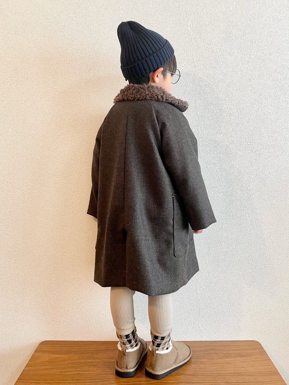 ホワイト系のニット/セーター、ブラウン系のチェスターコート、イエロー系のブーツを着用したキッズの冬コーディネートの2枚目の写真