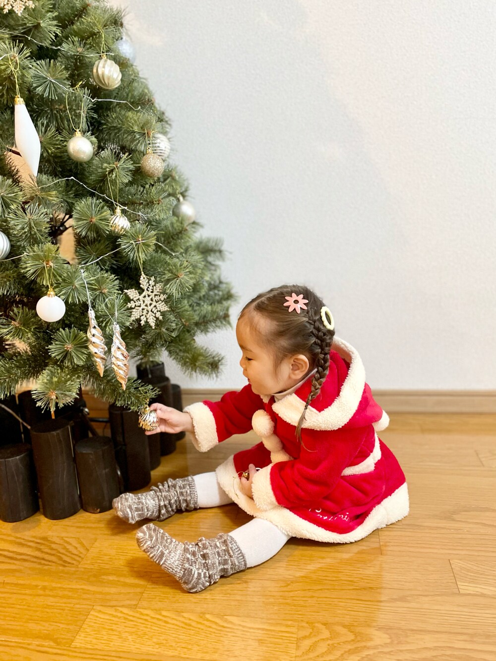 ベージュ系のTシャツ/カットソー、レッド系のワンピース、ベージュ系のブーツを着用したキッズの冬コーディネートの3枚目の写真