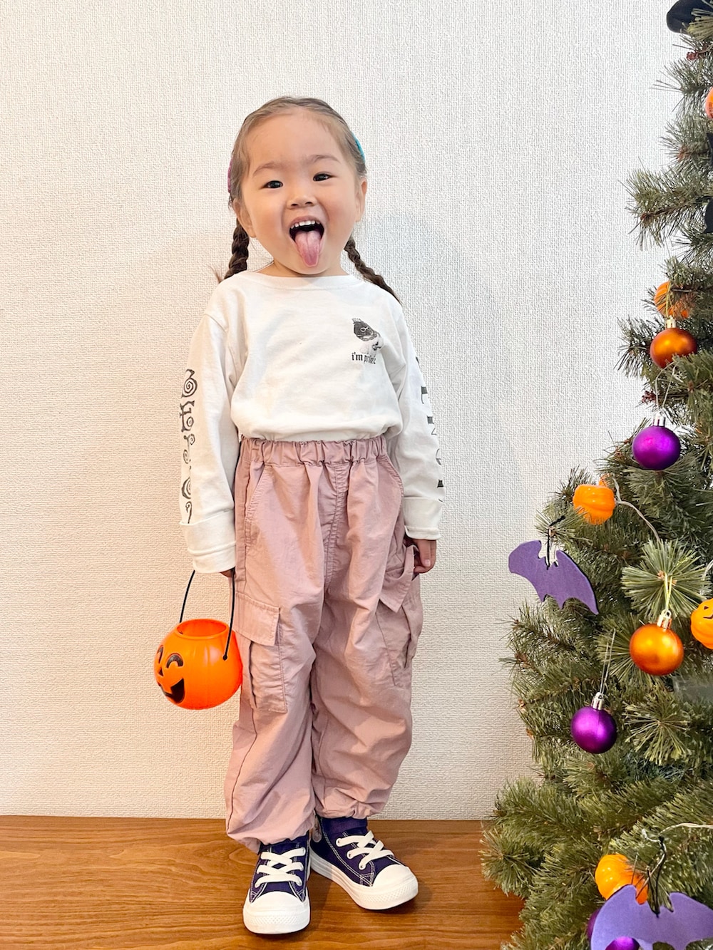 ホワイト系のTシャツ/カットソー、ピンク系のカーゴパンツ、パープル系のスニーカーを着用したキッズの秋コーディネートの2枚目の写真
