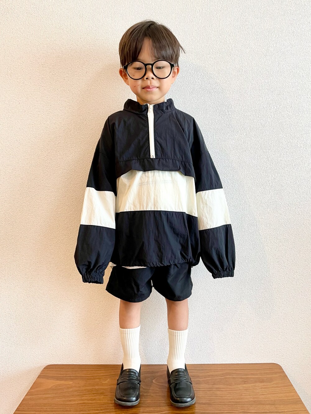 ブラック系のナイロンジャケット、ブラック系のその他パンツ、ブラック系のローファーを着用したキッズの秋コーディネートの2枚目の写真