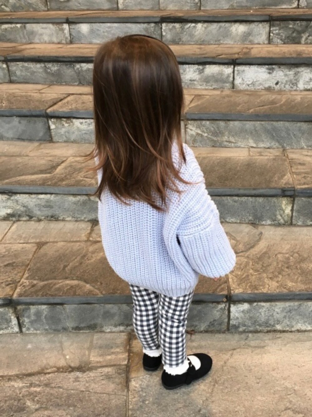 ベージュ系のTシャツ/カットソー、ブルー系のカーディガン/ボレロ、ブラック系のバレエシューズを着用したキッズの秋コーディネートの3枚目の写真