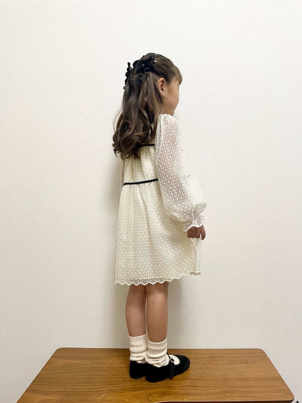 ホワイト系のワンピースを着用したキッズの秋コーディネートの2枚目の写真