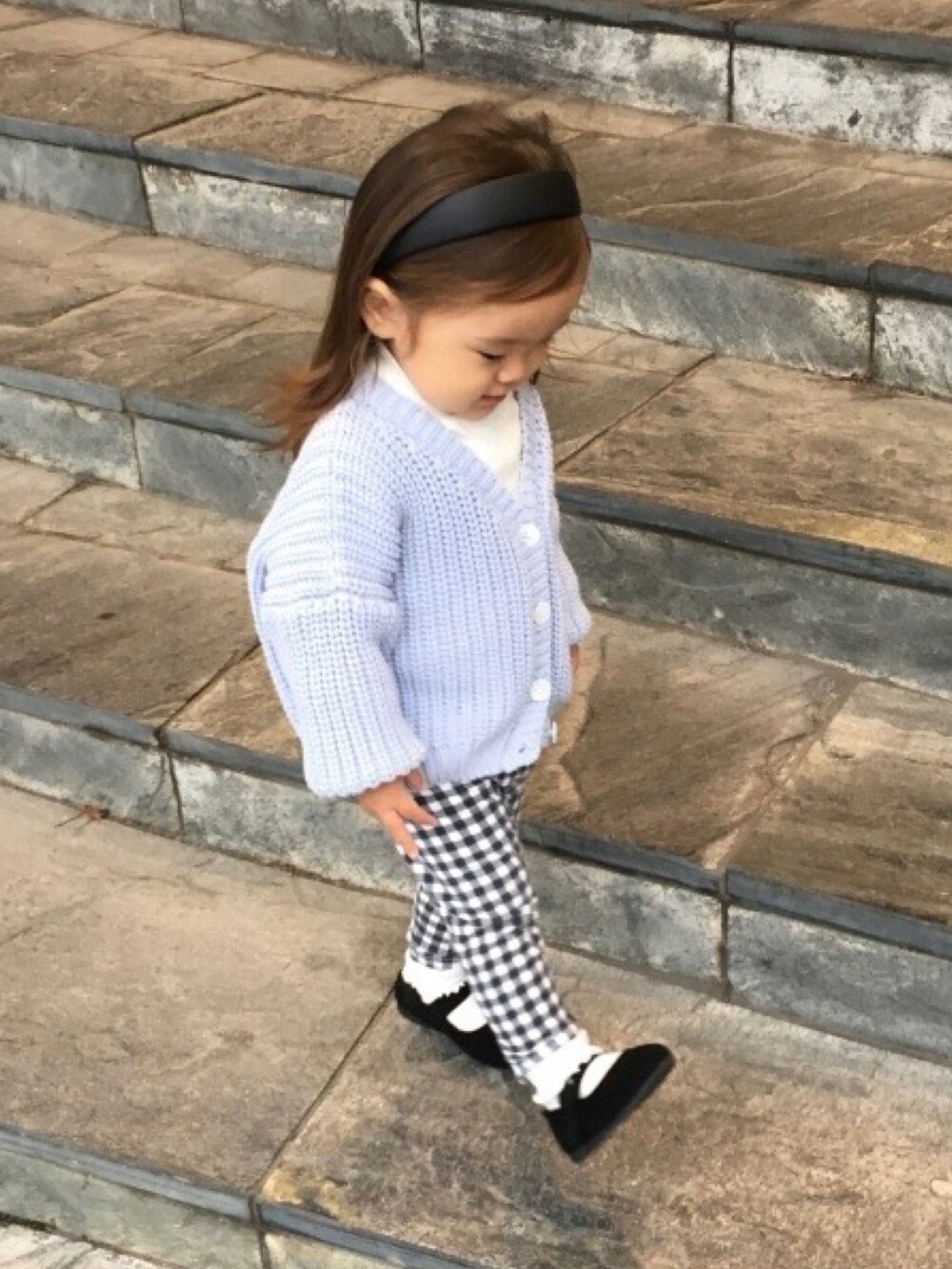 ベージュ系のTシャツ/カットソー、ブルー系のカーディガン/ボレロ、ブラック系のバレエシューズを着用したキッズの秋コーディネートの2枚目の写真