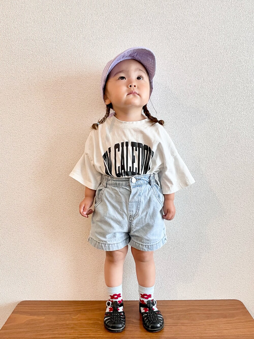 ホワイト系のTシャツ/カットソー、ブルー系のデニムパンツ、ブラック系のサンダルを着用したキッズの春コーディネートの2枚目の写真