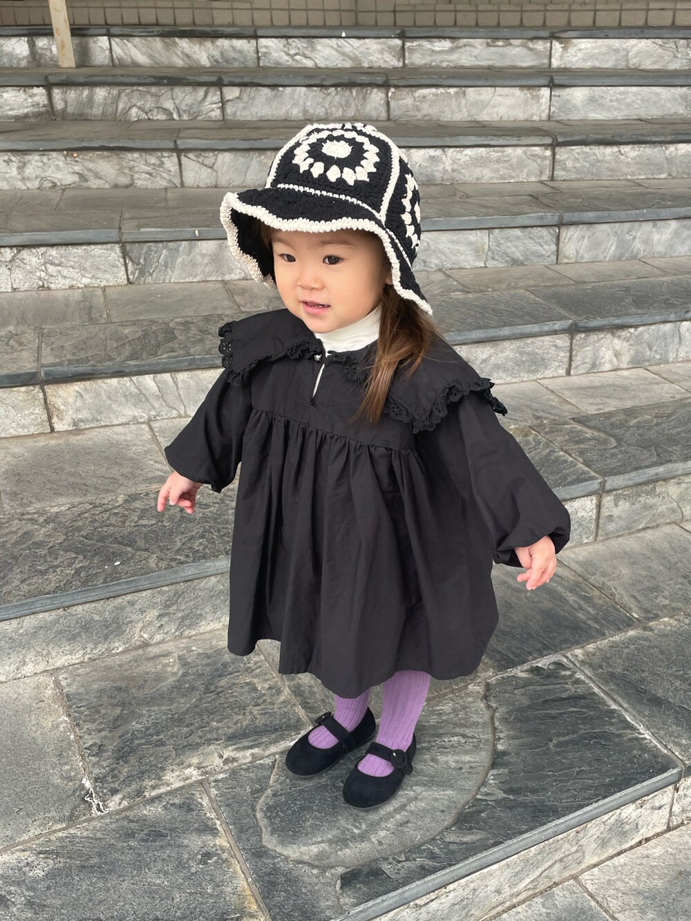 ベージュ系のTシャツ/カットソー、ブラック系のワンピース、ブラック系のバレエシューズを着用したキッズの冬コーディネートの3枚目の写真