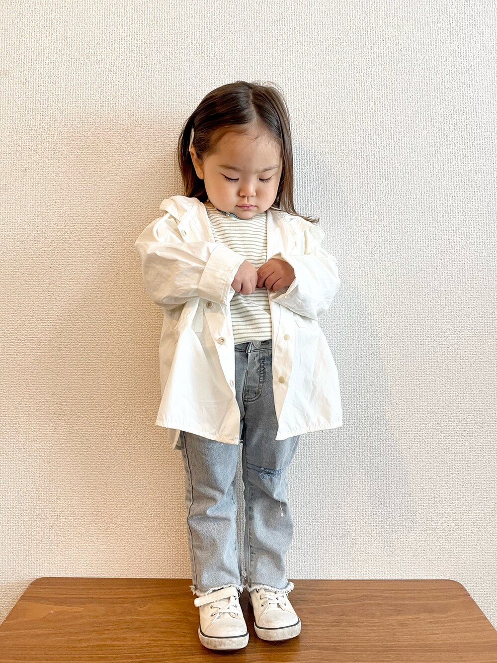 ホワイト系のマウンテンパーカー、グリーン系のTシャツ/カットソー、ブルー系のデニムパンツを着用したキッズの春コーディネートの3枚目の写真