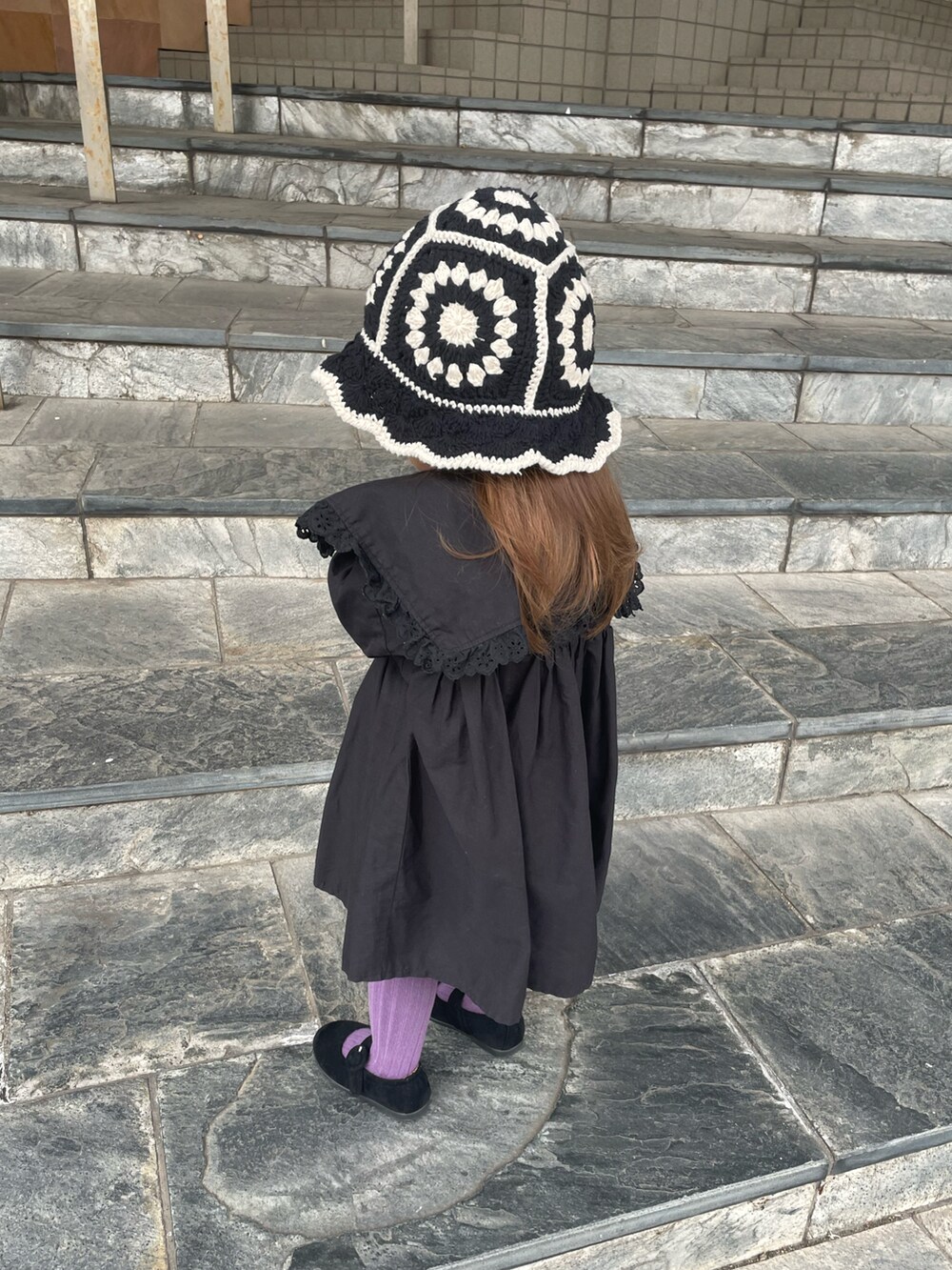 ベージュ系のTシャツ/カットソー、ブラック系のワンピース、ブラック系のバレエシューズを着用したキッズの冬コーディネートの4枚目の写真