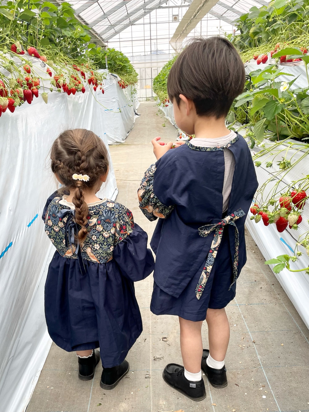 ブルー系のワンピース、ブラック系のブーツ、ブルー系のシャツ/ブラウスを着用したキッズの春コーディネートの2枚目の写真