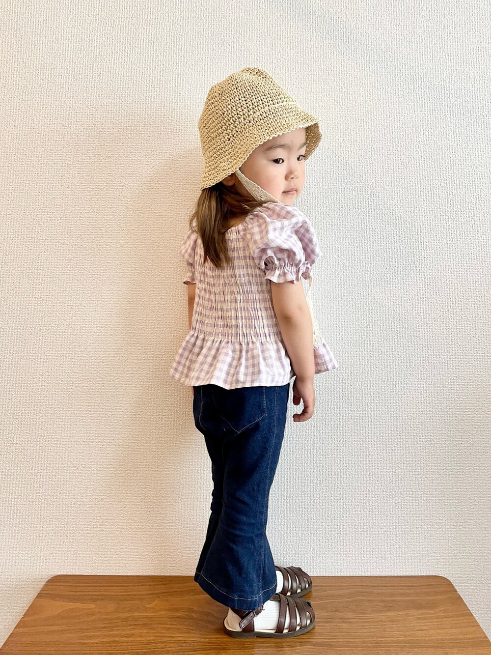 パープル系のシャツ/ブラウス、ブルー系のデニムパンツ、ブラウン系のサンダルを着用したキッズの春コーディネートの3枚目の写真