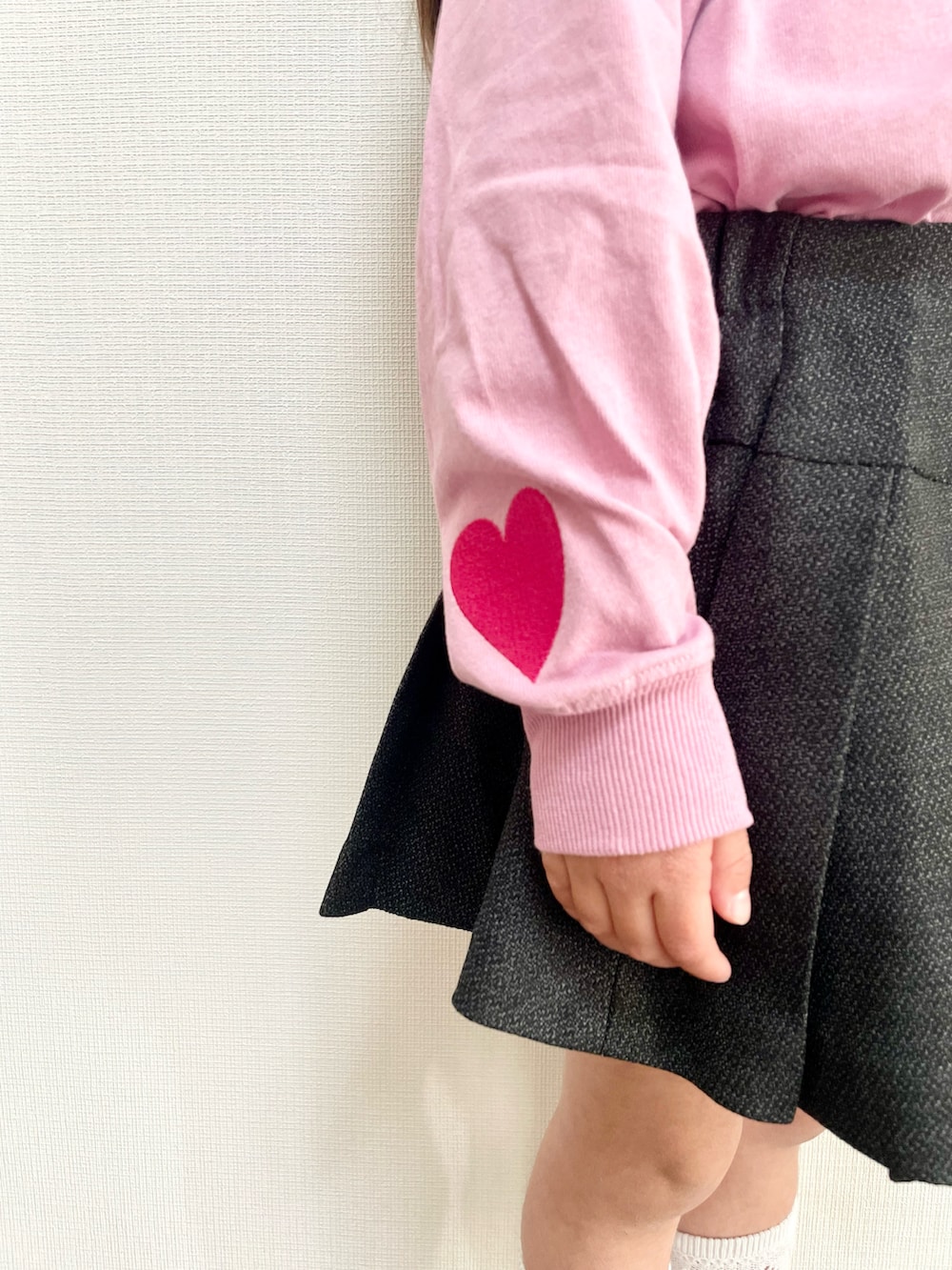 ピンク系のTシャツ/カットソー、グレー系のスカート、ブラック系のスニーカーを着用したキッズの春コーディネートの2枚目の写真