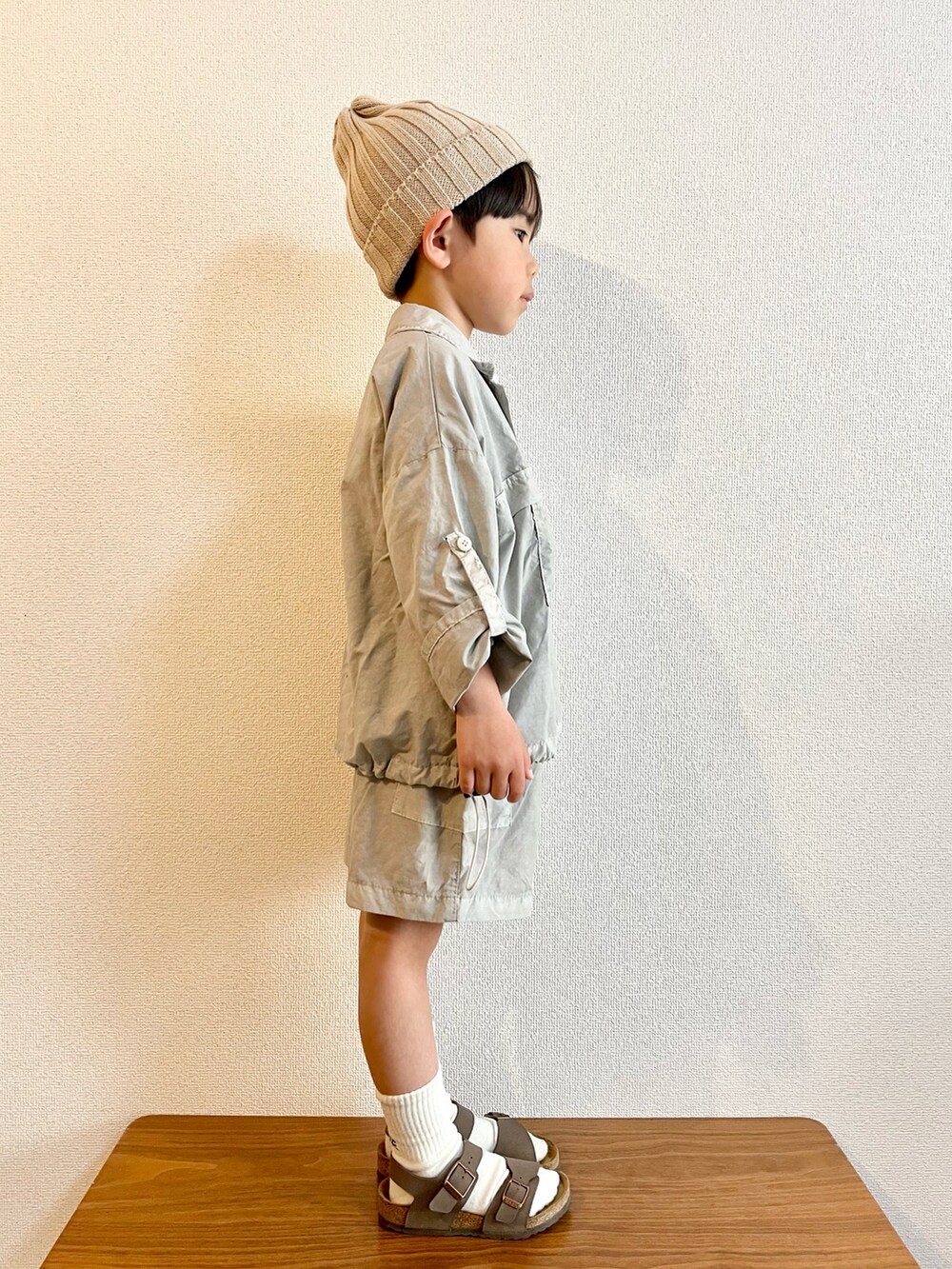 グレー系のTシャツ/カットソー、ブラウン系のサンダル、ベージュ系のニットキャップ/ビーニーを着用したキッズの春コーディネートの2枚目の写真