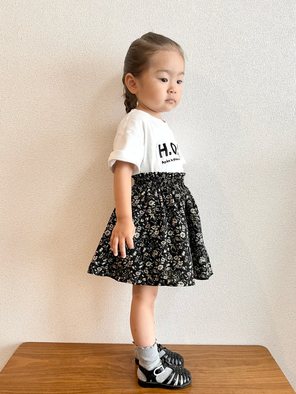 ブラック系のTシャツ/カットソー、ブラック系のスカート、ブラック系のサンダルを着用したキッズの夏コーディネートの2枚目の写真