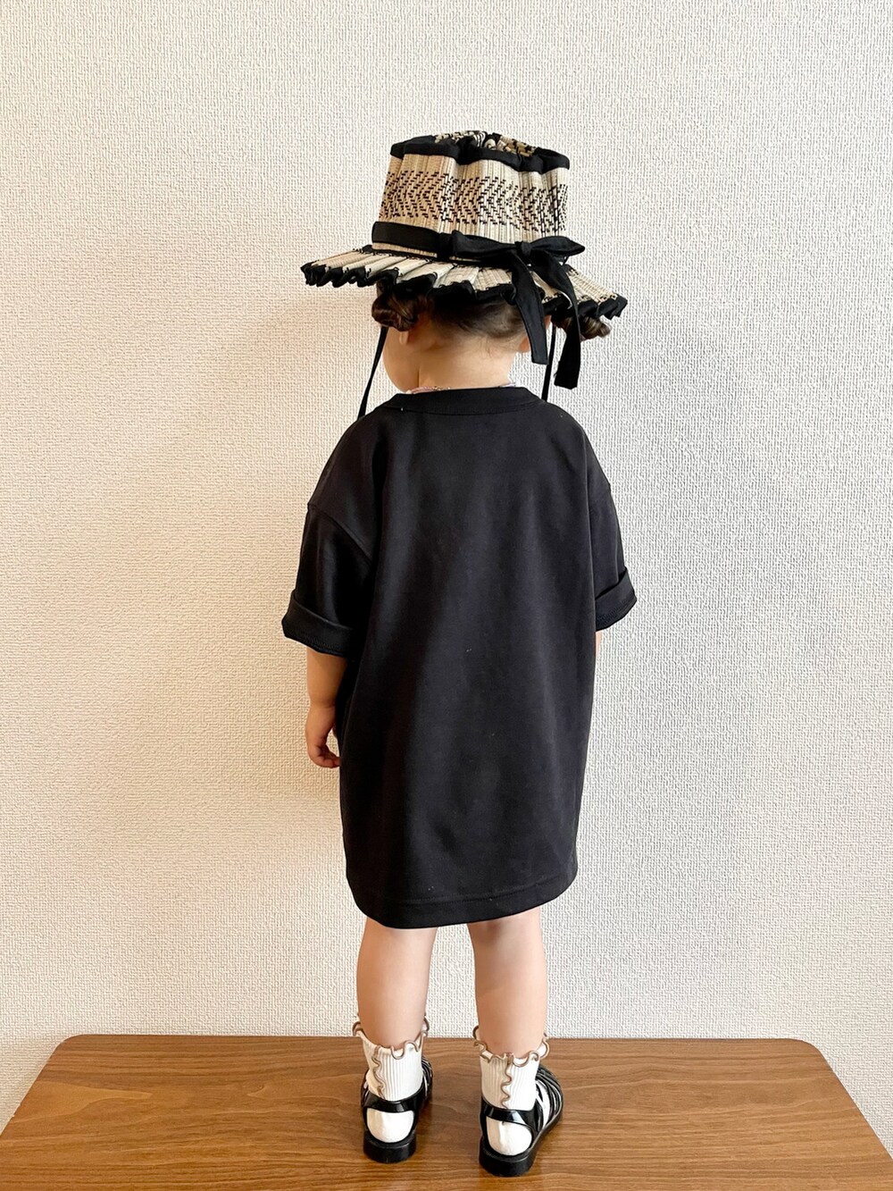 ブラック系のTシャツ/カットソー、ブラック系のサンダル、ブラック系のハットを着用したキッズの夏コーディネートの2枚目の写真