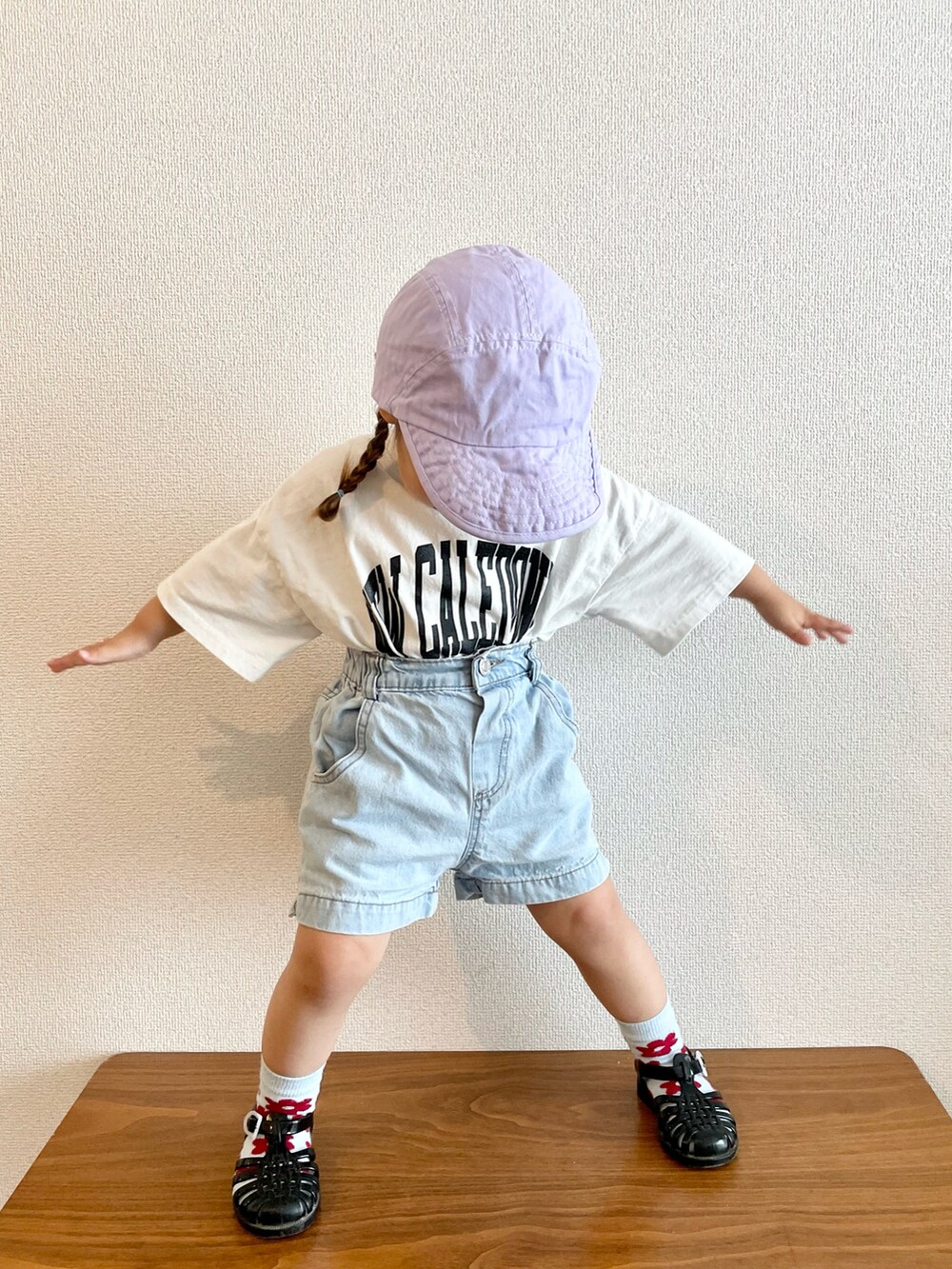 ホワイト系のTシャツ/カットソー、ブルー系のデニムパンツ、ブラック系のサンダルを着用したキッズの春コーディネートの3枚目の写真