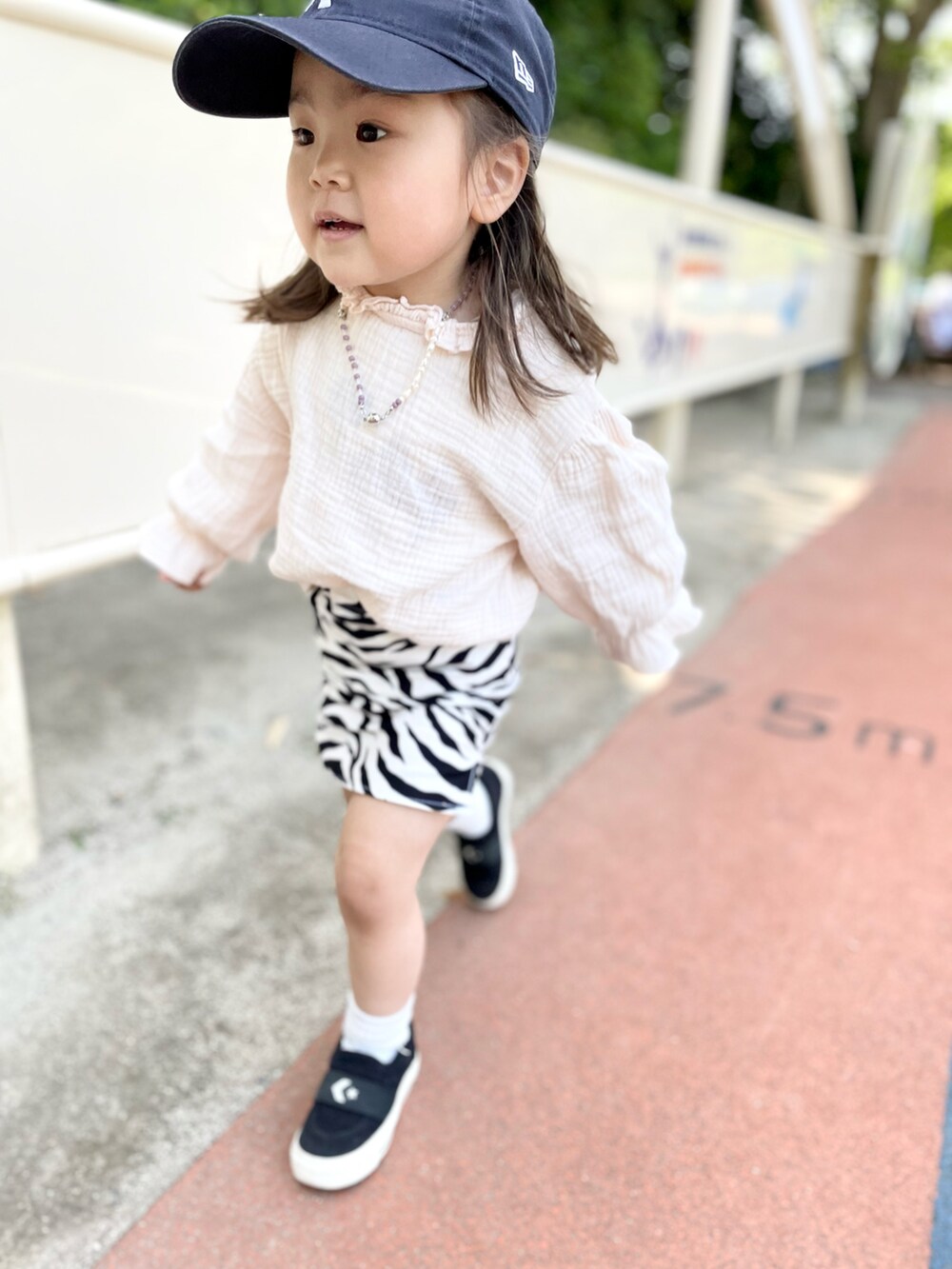 ピンク系のシャツ/ブラウス、ブラック系のスカート、ブラック系のスニーカーを着用したキッズの春コーディネートの2枚目の写真